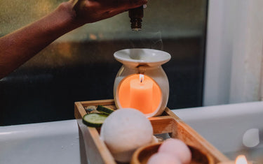 Hand dropping essential oils into an oil burner